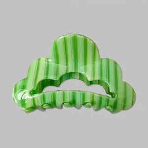 Détail d'une pince à cheveux en acétate avec motif rayé vert et forme de nuage