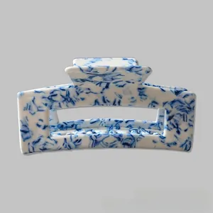 Detail showing blue and white porcelain pattern on a 10cm square hair claw clip