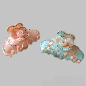 Detailed comparison of pink and blue marble resin flower hair claws with rhinestones