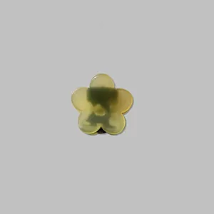 Détail d'une pince à cheveux fleur en résine vert citron translucide sur fond gris