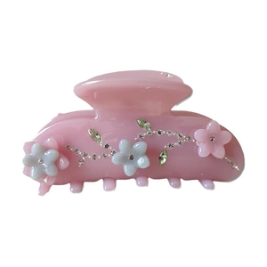 Floral hair claw clip with pink resin, rhinestone flowers, and green gemstone leaves