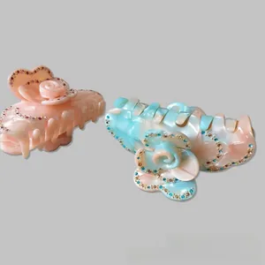 Macro detail of acetate flower hair claw clips with colorful rhinestones and grip teeth