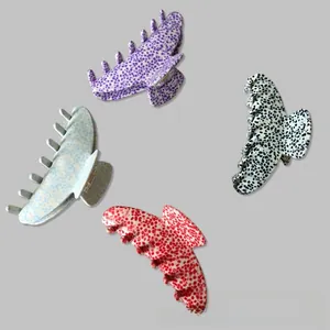 Detail of four large French-style shark clips featuring polka dot patterns in four colors
