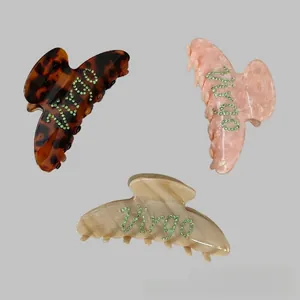 Detail showing marble texture hair claws with Virgo rhinestone lettering in various colors