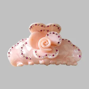 Close-up of pink marble texture rose hair claw with sparkling pink rhinestones