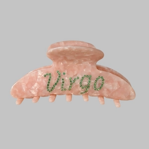 Detail of pink marble resin hair claw clip with Virgo green rhinestone lettering design