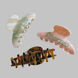 Three Scorpio rhinestone claw clips in marble white, peach pink and tortoiseshell patterns