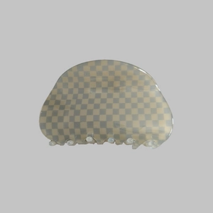 Detail shot of the grey and white checkered acetate hair claw clip with a semi-circle design