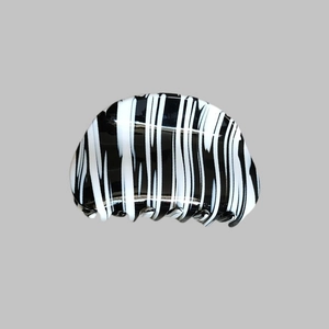 Close-up of zebra pattern acetate hair claw clip with polished finish and dense teeth
