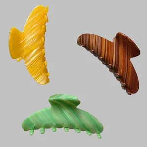 Trois pinces à cheveux élégantes en acétate coloris jaune, marron et vert rayé