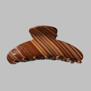 Détail d'une grande pince à cheveux en acétate motif ambre écaille avec fini brillant