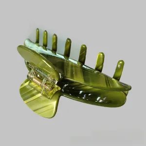 Detail shot of a large green acetate shark hair claw with elegant dark stripes