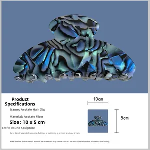 Detail view of large acetate claw clip with blue-green marble texture for women