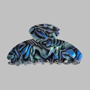 Detailed view of large acetate hair claw clip with blue marble pattern and glossy finish