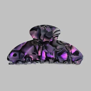 Detailed macro view of large acetate claw clip with dark purple and black marble textures