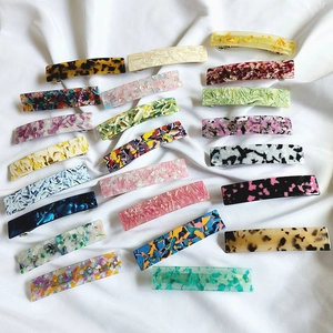 Flat lay view of various french acetate hair clips with marble and floral patterns