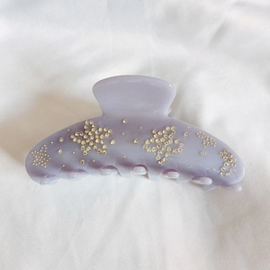 Macro detail of lavender acetate flower hair claw clip with sparkling star crystal inlay