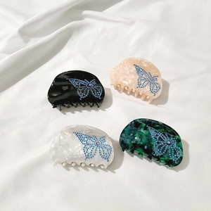 Set of four semicircular butterfly hair claws with rhinestones in marble colors