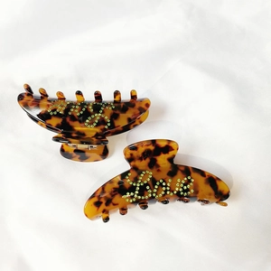 Detail of tortoise shell hair claw clips with green rhinestone Love lettering