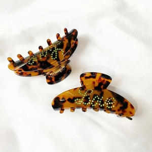 Detail of tortoiseshell hair claw clips with green rhinestone Love letters decoration