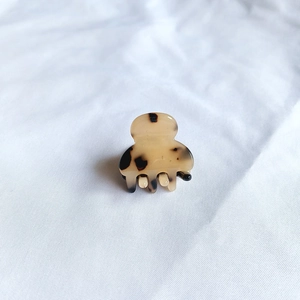 Detailed top view of a mini acetate hair claw clip featuring classic leopard print