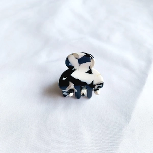 Detail view of mini marble acetate hair claw clip with a durable silver metal spring