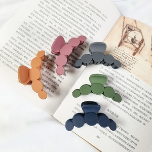 Set of 5 minimalist Morandi color hair claws in matte finish on an open book