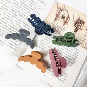 Five Morandi color matte shark hair clips arranged on a vintage book backdrop