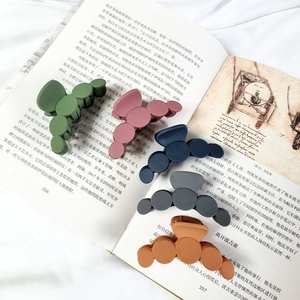 Set of 5 matte Morandi colored hair claws with unique round spherical design on a book