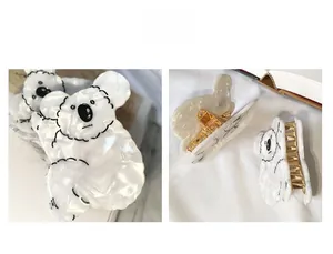 Détail de la pince koala mignonne montrant la texture acétate marbre blanc et le clip doré