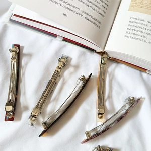 Dettaglio del fermaglio per capelli alla francese in acetato con motivi marmorizzati