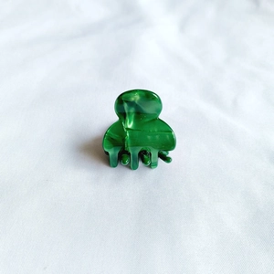 Detail view of mini marble green acetate hair claw clip with glossy polished finish