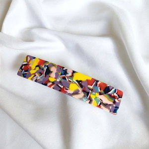 Detailed close-up of French acetate hair clip featuring colorful abstract stone patterns