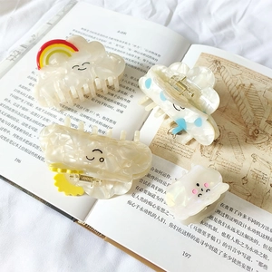 Set of four pearlescent cloud hair claws with rainbow and smiley face accents for women