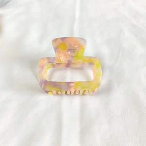 Detail view of small square tortoiseshell acetate hair claw clip with marble texture