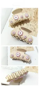 Gros plan sur la pince à cheveux beige avec fleurs roses et strass brillants incrustés