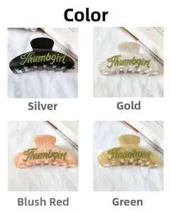 Détail de quatre grandes pinces à cheveux en acétate avec lettrage en strass de couleurs