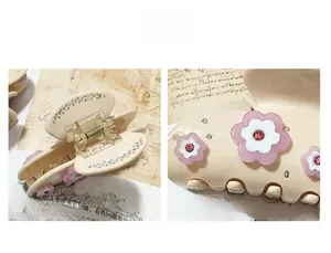 Détail d'une pince à cheveux crème avec fleur rose ornée de strass brillants et élégants