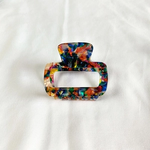 Detailed macro view of small rectangular acetate claw clip with colorful marble pattern
