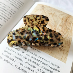 Macro shot of large iridescent shell-texture hair claw clip with strong metal spring