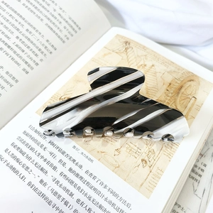 Macro detail of large marble pattern hair claw clip on an open book background