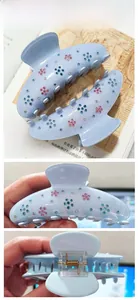 Détail de la pince à cheveux à fleurs en strass bleu clair avec ressort doré et paillettes