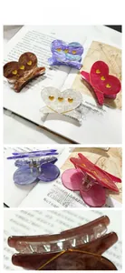 Detail of heart-shaped acetate hair claws with marble texture and gold heart accents