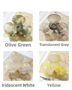 Detailed view of four acetate floral hair claws in olive green, gray, white, and yellow