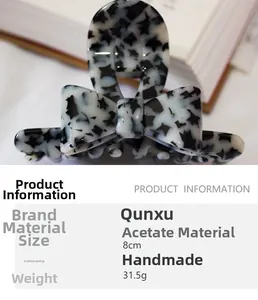 Detail view of handmade 8cm acetate bow hair claw with elegant black and white floral pattern