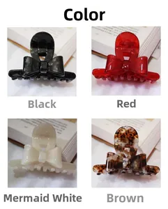 Detail view showing four colors of bow-knot hair claws on open books for selection