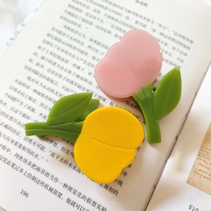 Pinces à cheveux tulipes françaises rose et jaune en acétate sur un livre ouvert