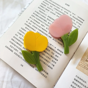 Barrettes tulipe en acétate style français en jaune et rose sur une page de livre