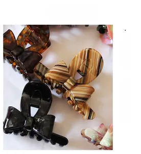 Detailed view of acetic acid bow hair claws in various vintage patterns and colors