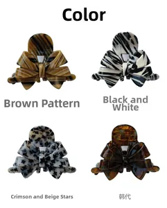 Detail of four acetate bow hair claws in tortoiseshell, star, and cow print patterns